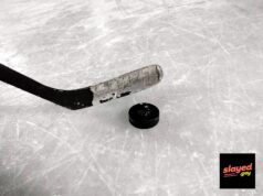 The Irina Foundation Is Real Now, and Honestly, We Need a Minute An ice hockey stick and puck resting on rink ice